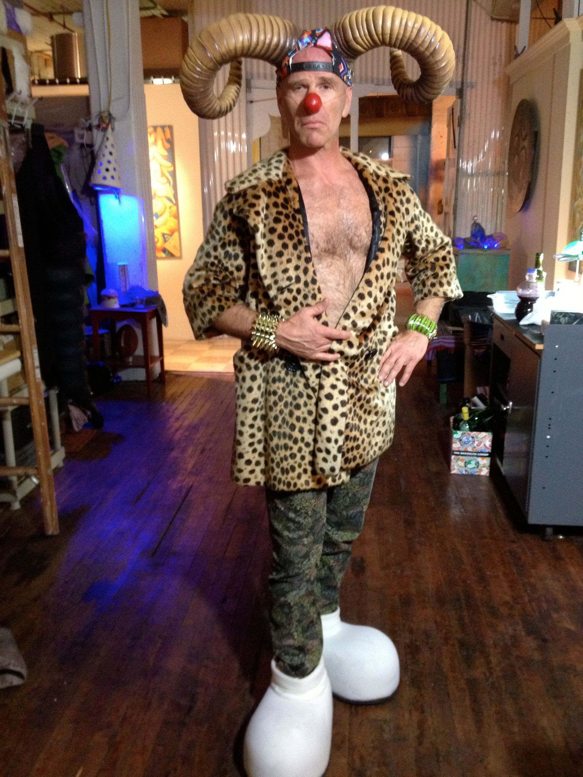 A man in a clown costume with horns and a red nose