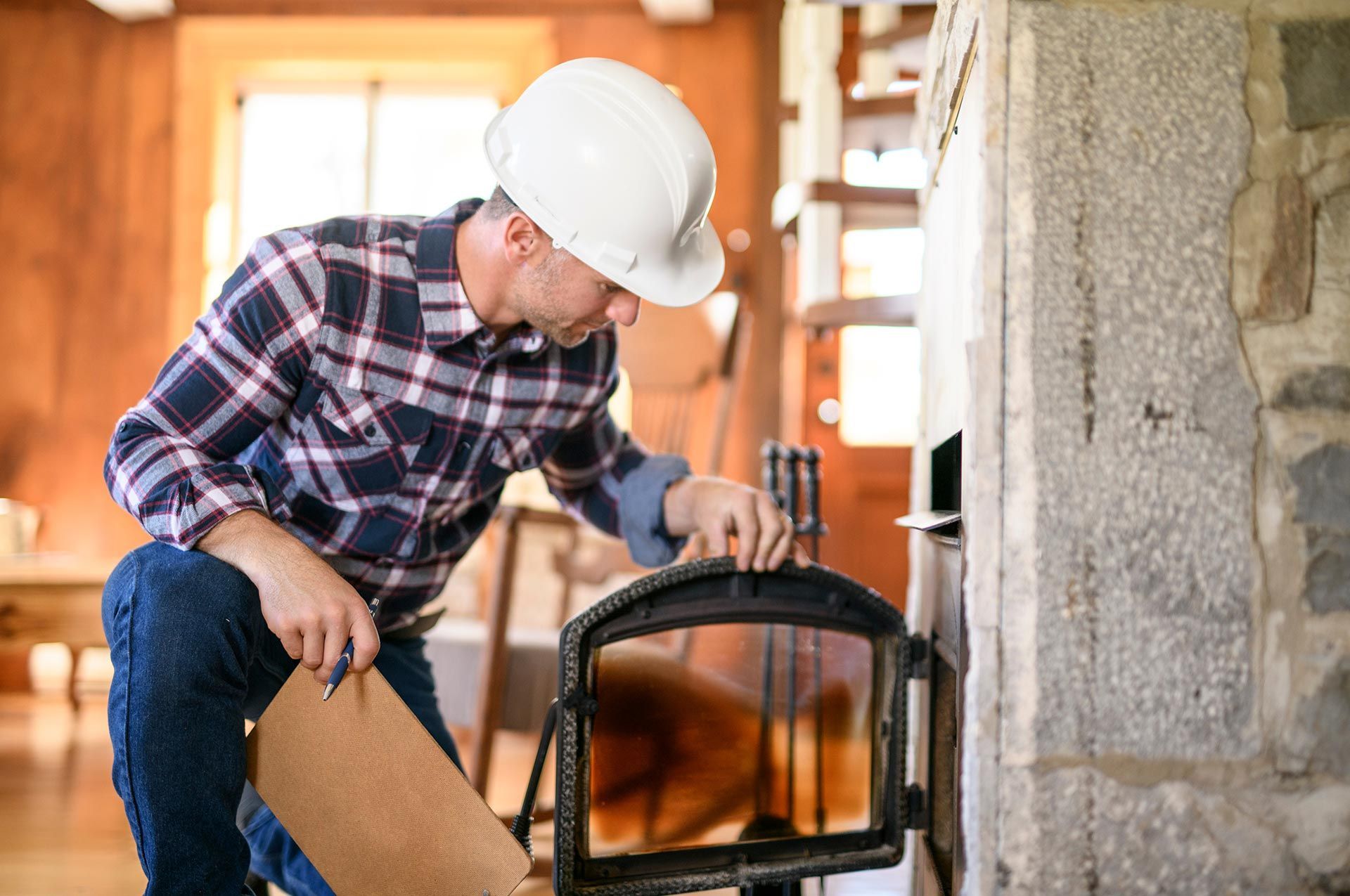 Worker inspecting a chimney indoors to be sure everything is well.