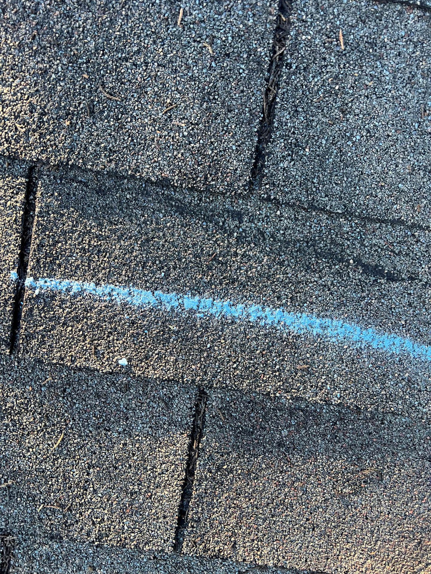 A close up of a roof with a blue line drawn on it.