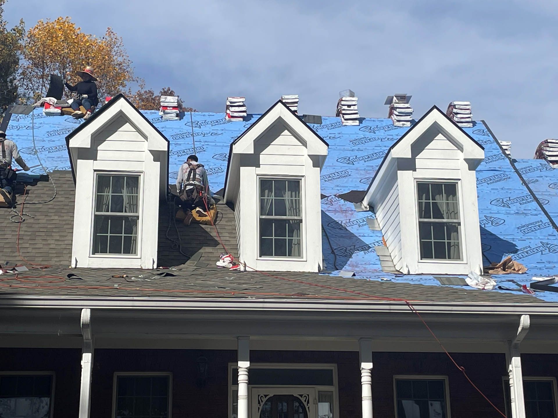 A group of people are working on the roof of a house.