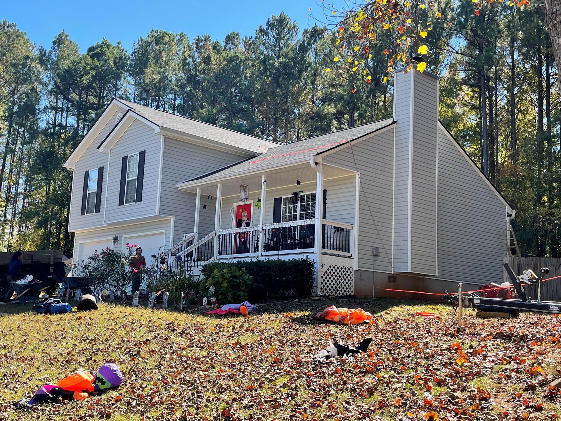 A house with a porch and a lot of leaves in front of it