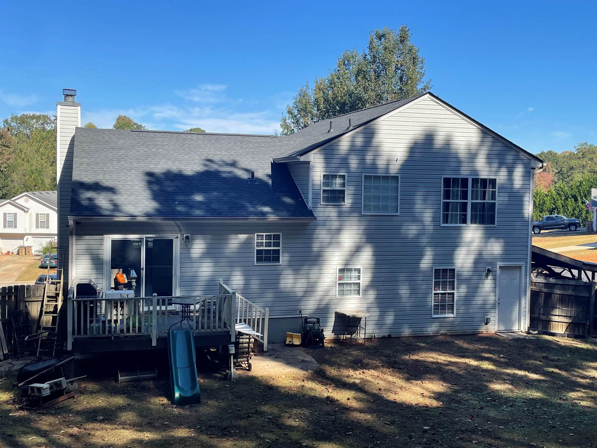 The back of a house with a deck and a lot of windows.
