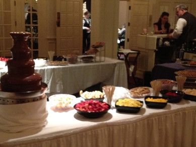 a table with a chocolate fountain and bowls of food on it