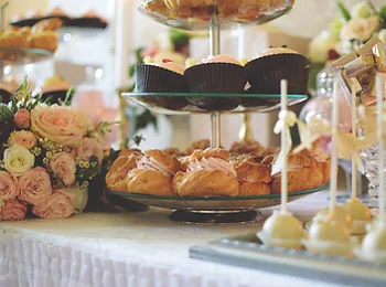 a table topped with a variety of desserts and flowers .