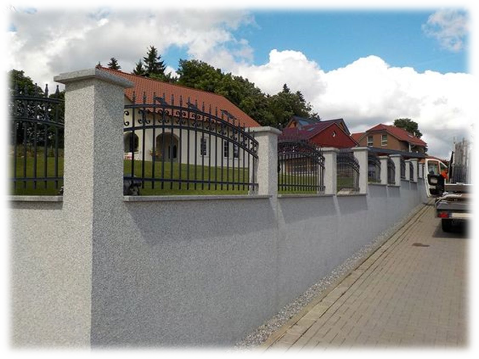 Un muro bianco con una recinzione metallica attorno