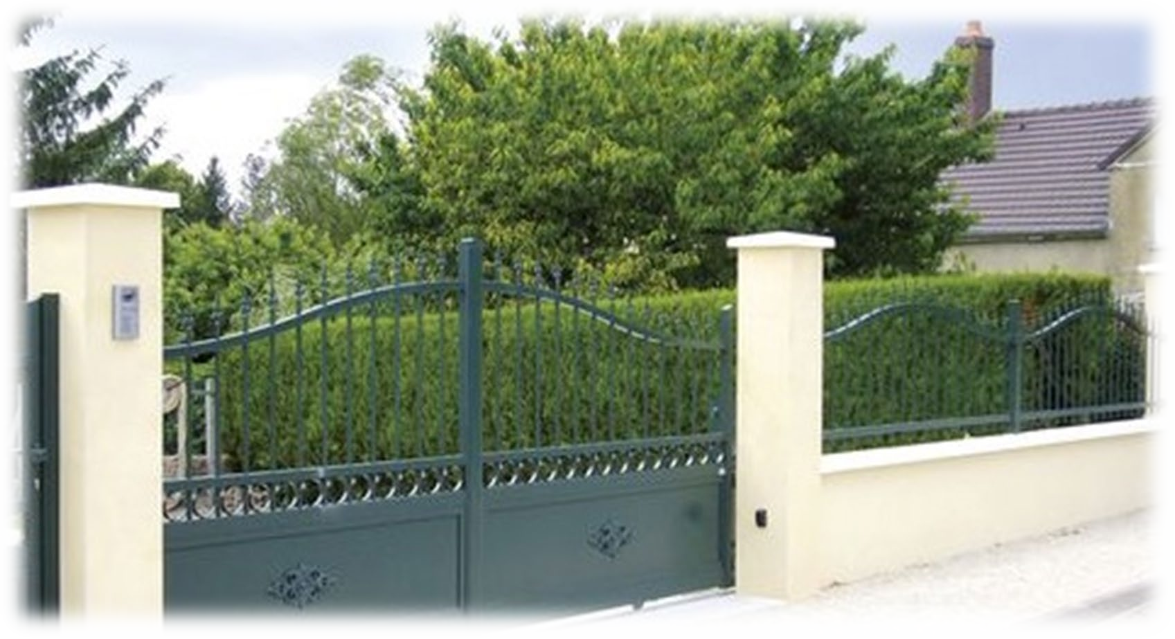Una recinzione con un cancello e una casa sullo sfondo