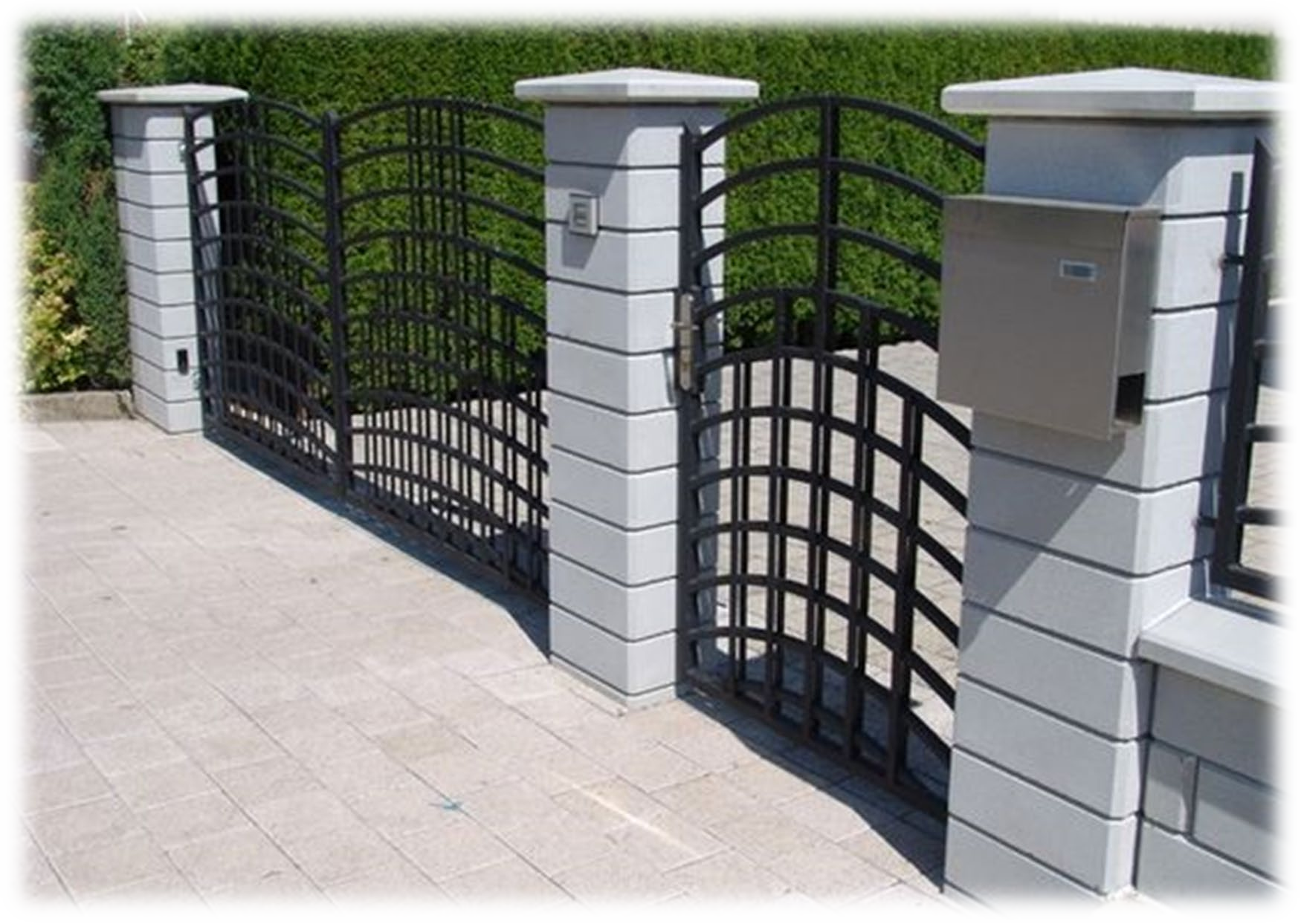 Una staccionata bianca con un cancello nero e una cassetta postale