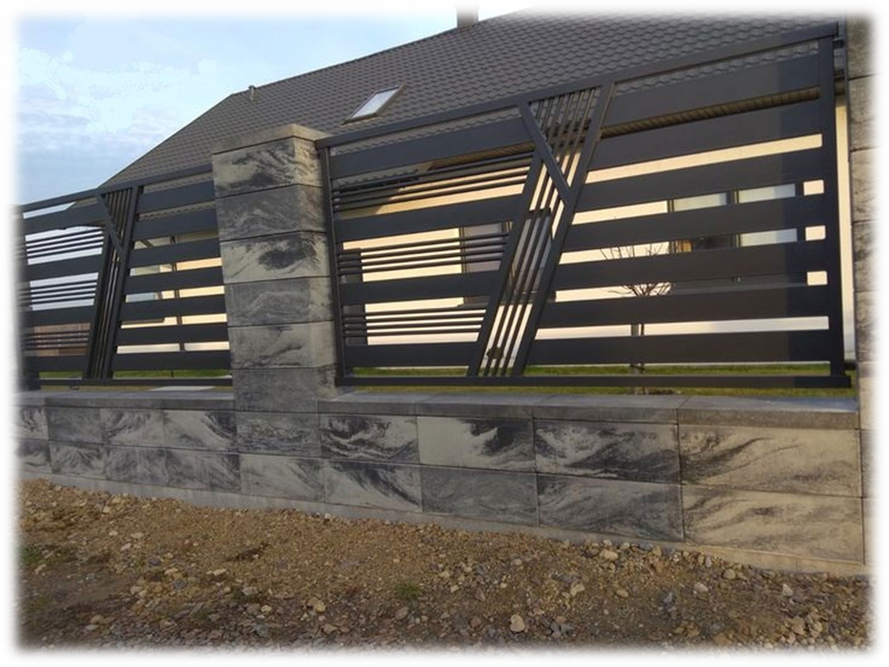 Davanti a una casa c'è una recinzione fatta di mattoni e metallo.