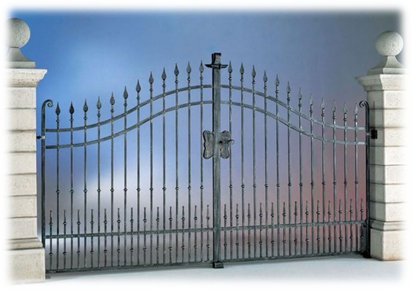 Un cancello in ferro battuto è circondato da pilastri in pietra