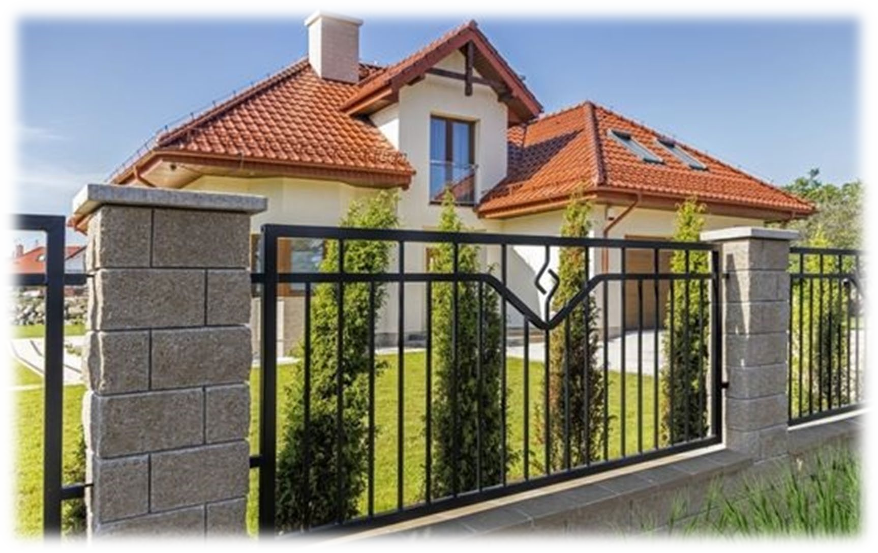 Una casa con il tetto rosso è dietro una recinzione nera