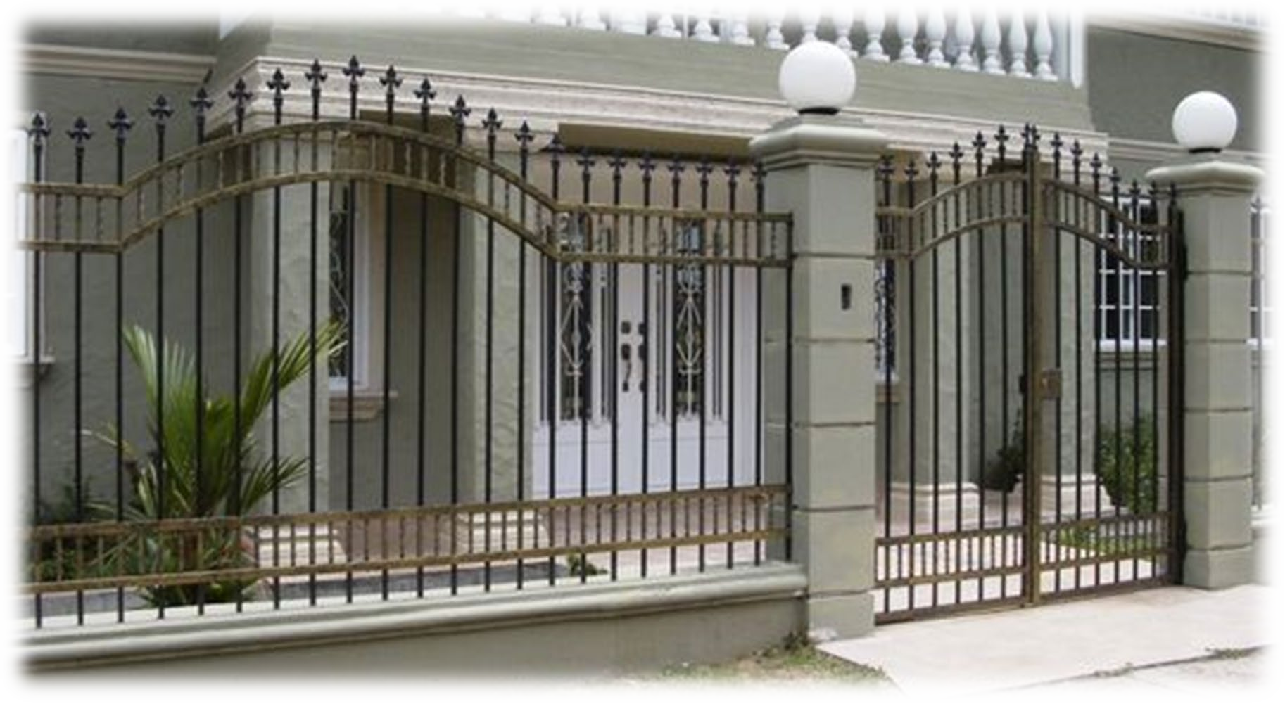 Una casa con una recinzione in ferro battuto intorno