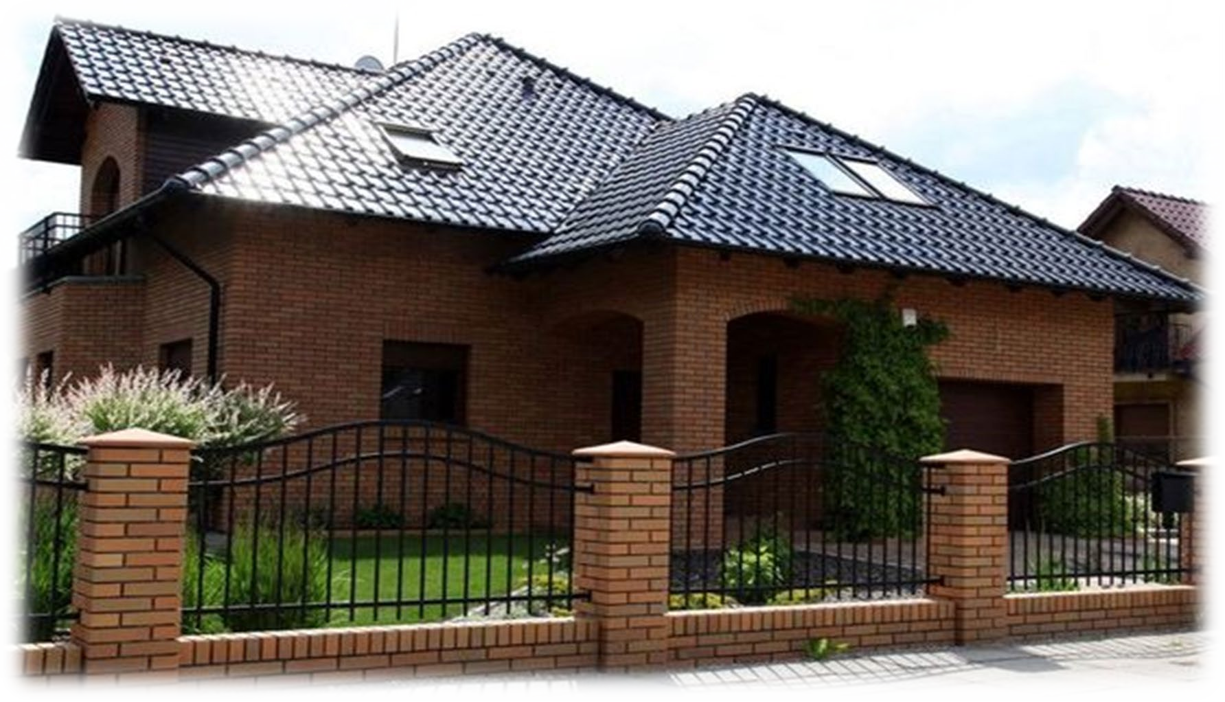 Una grande casa in mattoni con un tetto di tegole nere