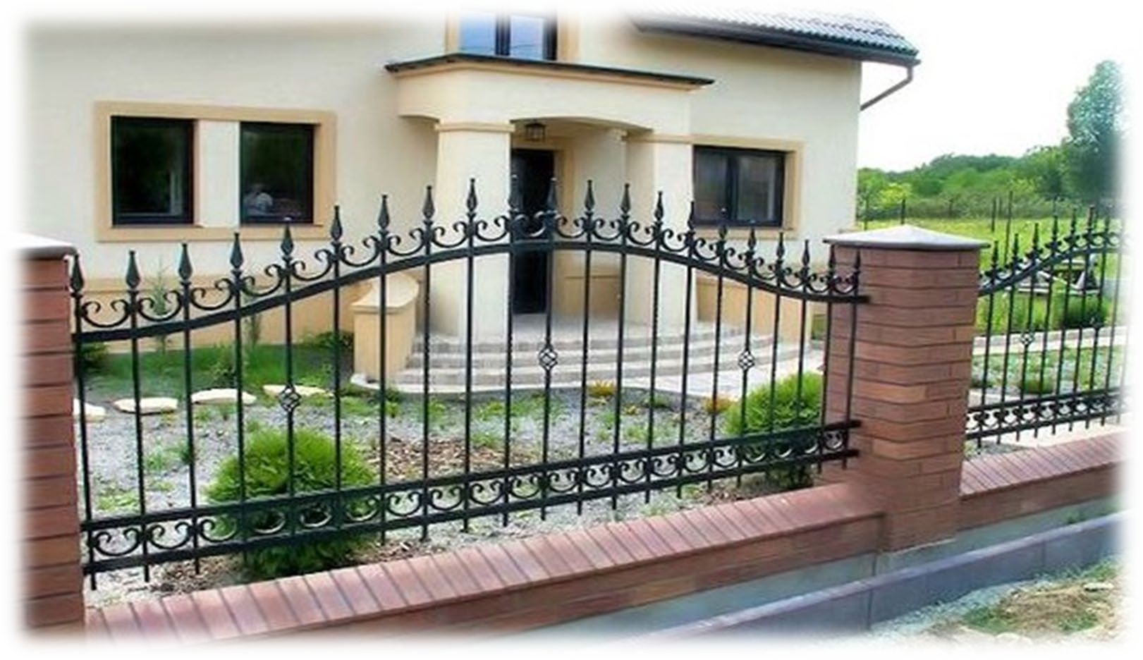 Una casa con una recinzione in ferro battuto davanti