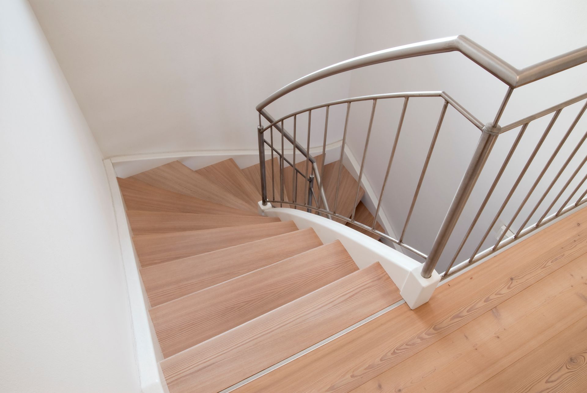 Una scala di legno con ringhiera di metallo in una casa.