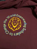 A maroon shirt with a lion on it and the words `` change the world ! empowering scholars to change the world ! ''