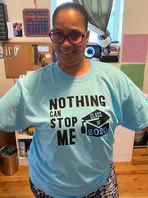 A woman is wearing a t-shirt that says `` nothing can stop me ''.