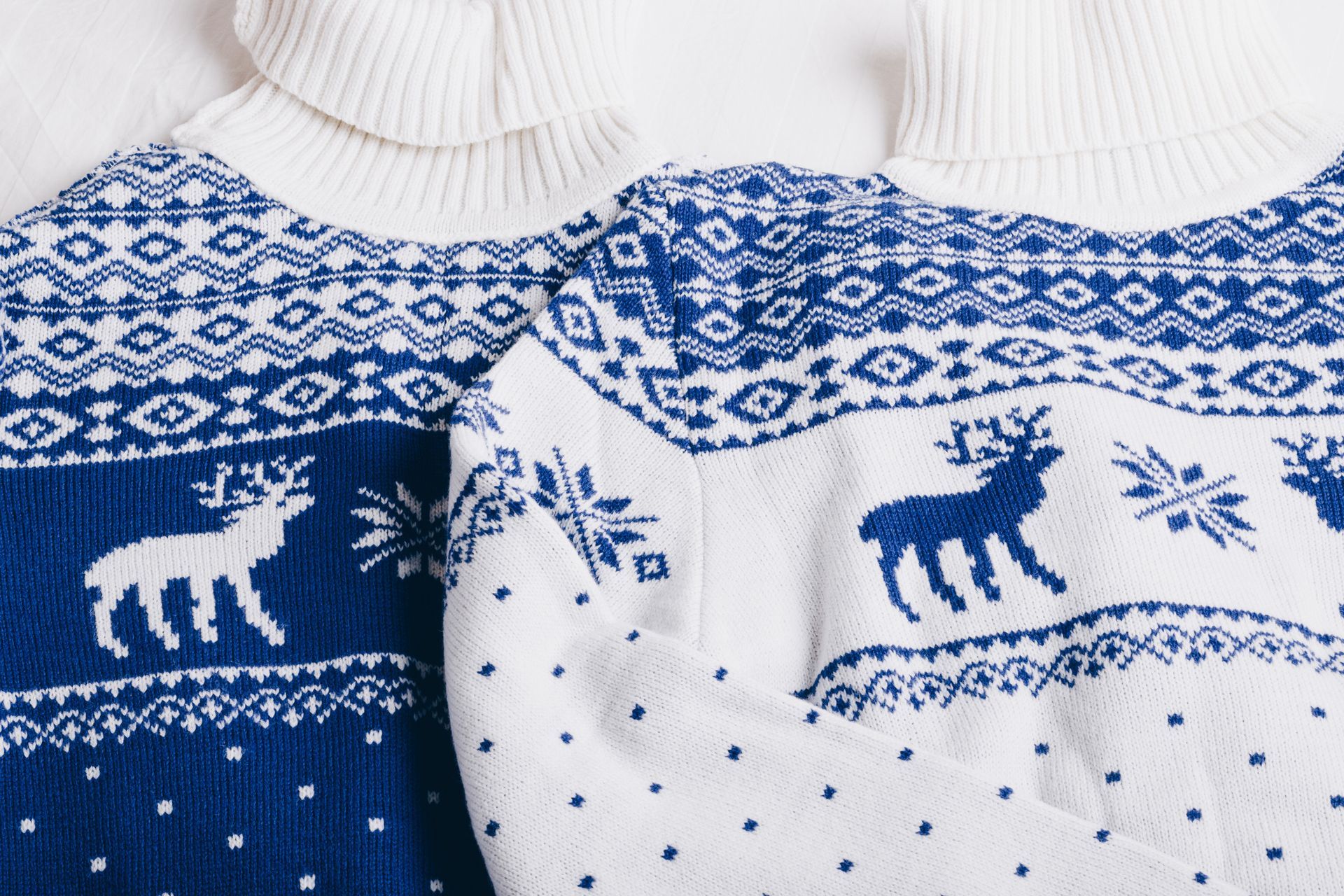 Two blue and white sweaters with deer and snowflakes on them