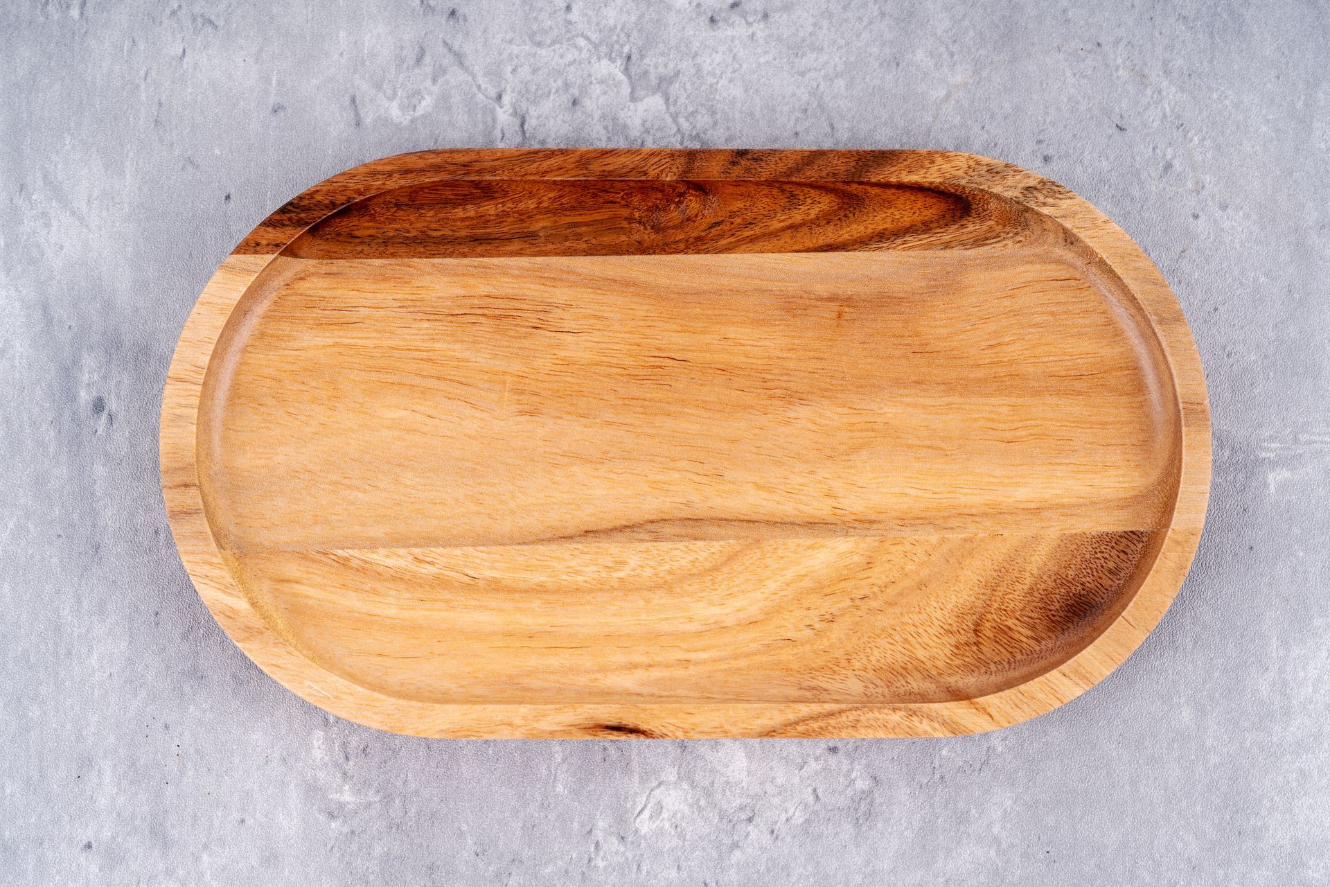 A wooden tray is sitting on a concrete surface.