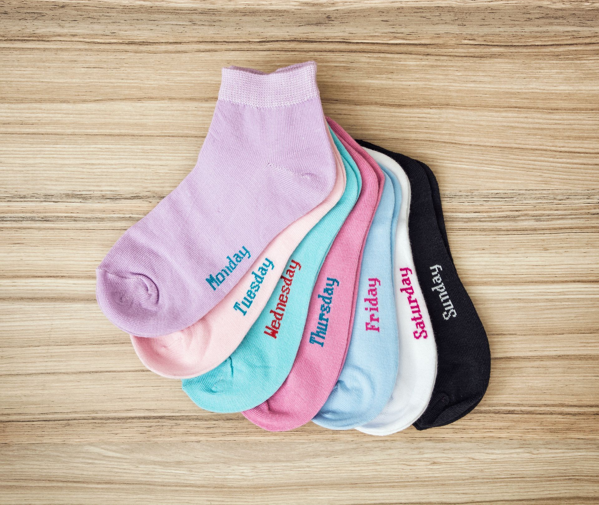 A stack of socks with the days of the week embroidered on them