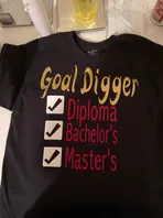 A black t-shirt with the words `` goal digger diploma bachelor 's master 's '' written on it.