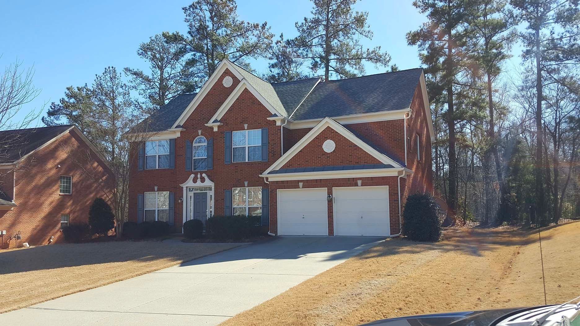 A large brick house with a car parked in front of it