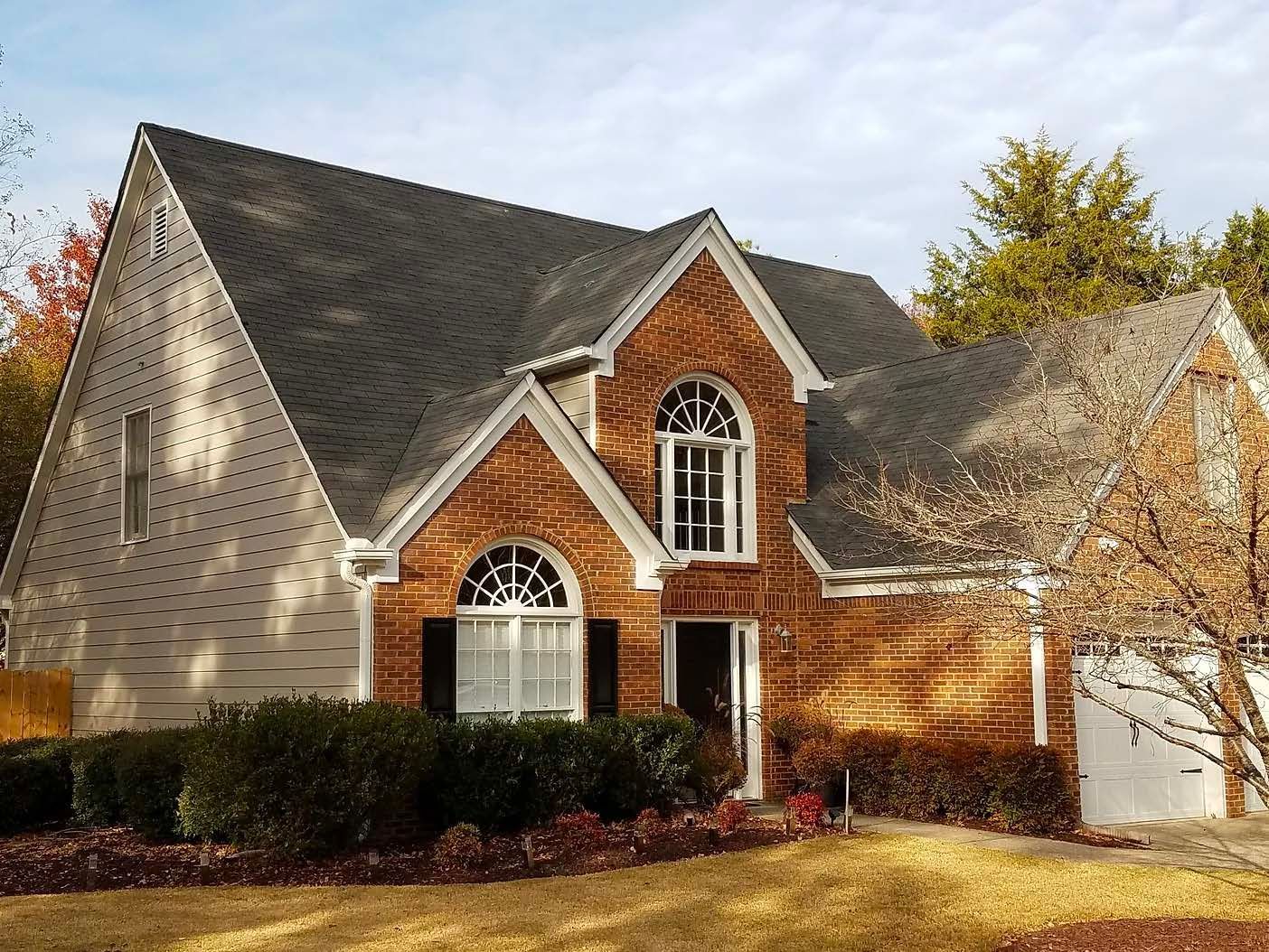 A large brick house with a black roof
