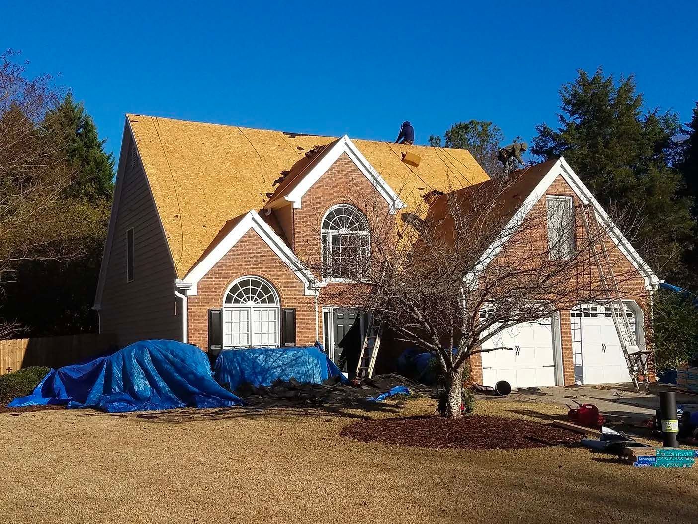 A large brick house with a wooden roof is being remodeled.
