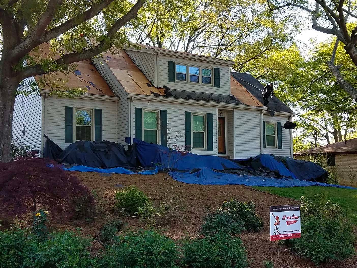 A house is being remodeled with a sign in front of it.