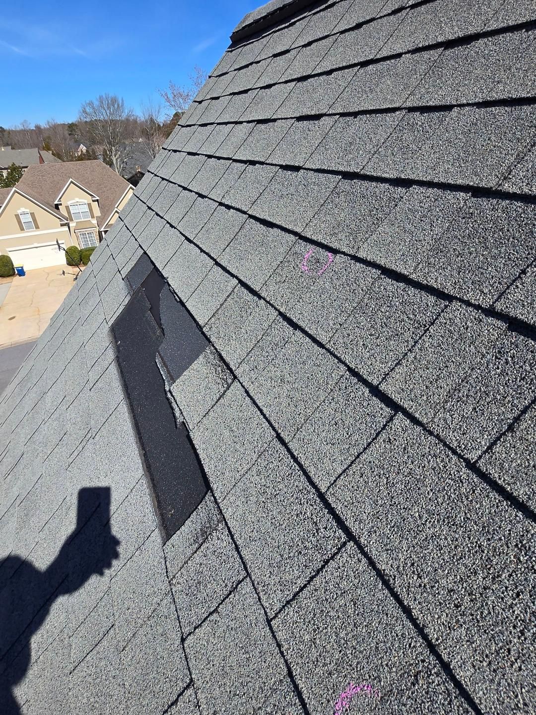 Sliding shingle caused by high winds.