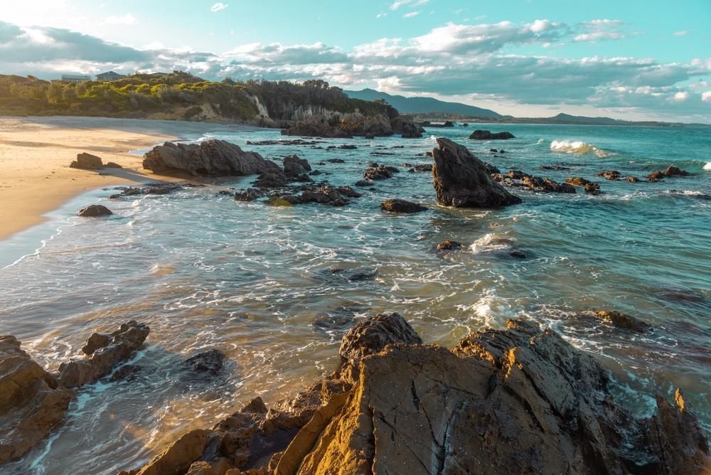 There Are A Lot Of Rocks On The Beach Near The Ocean — Southern Turf Supplies In Bermagui, NSW