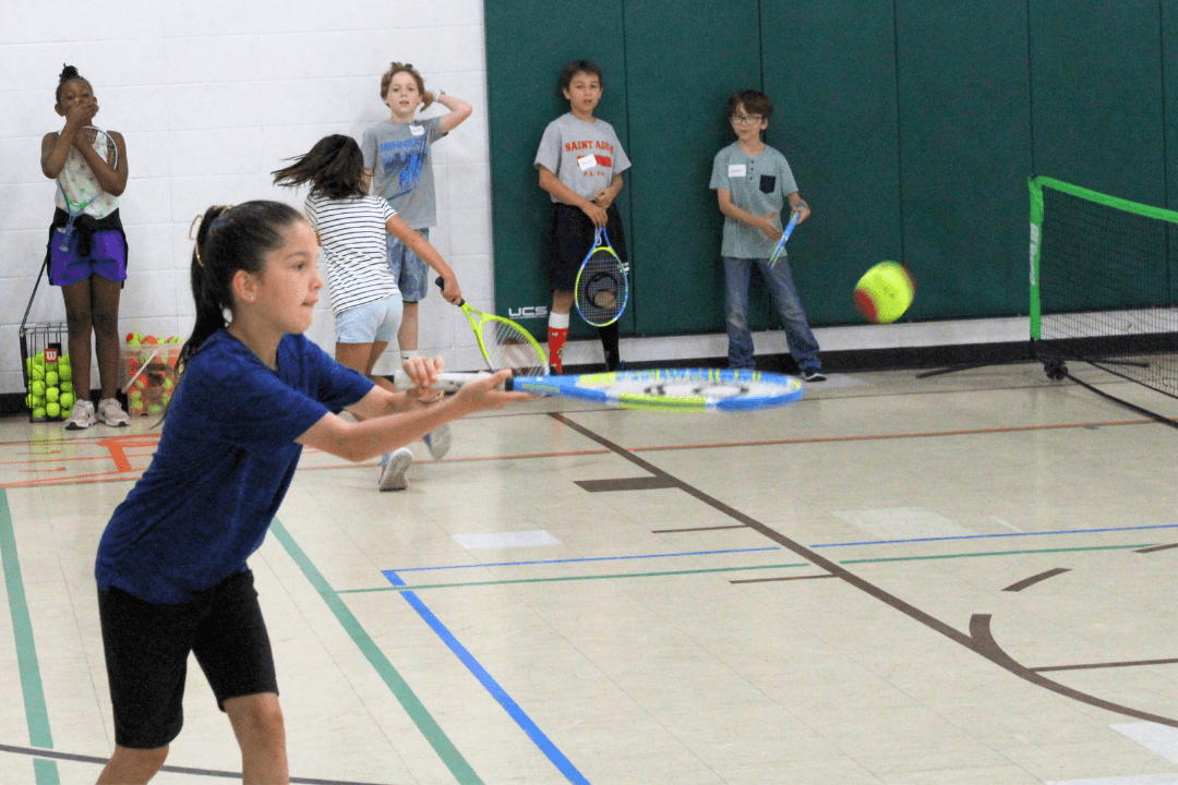 youth playing tennis in the gym