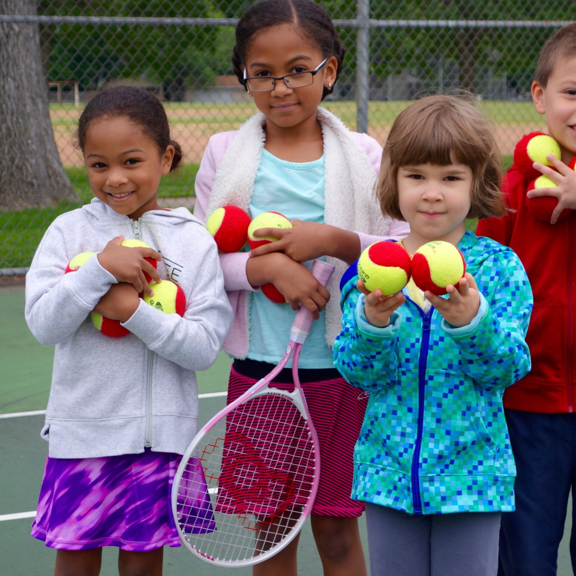 beginner tennis players holding tennis balls