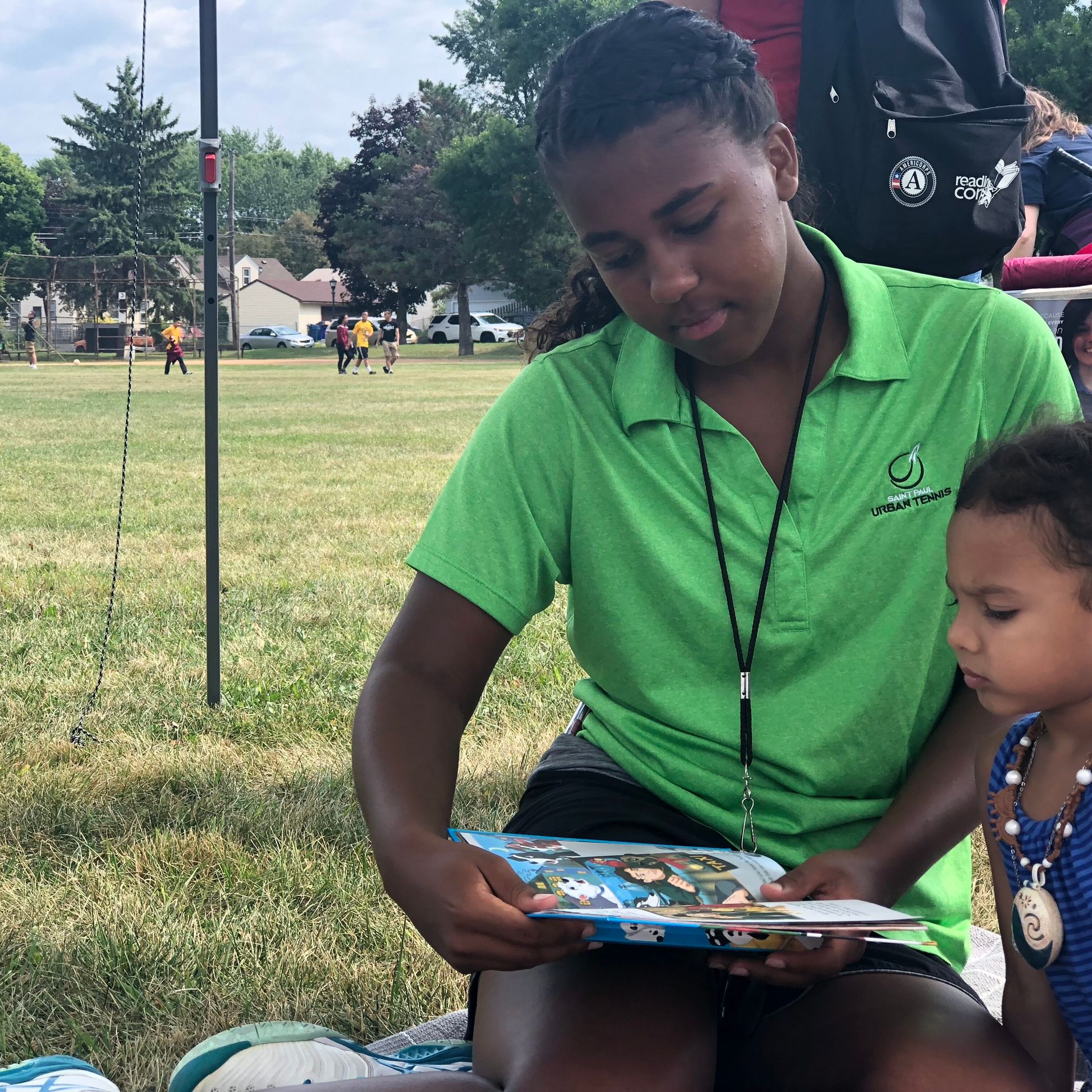 youth tennis coach reading to kids