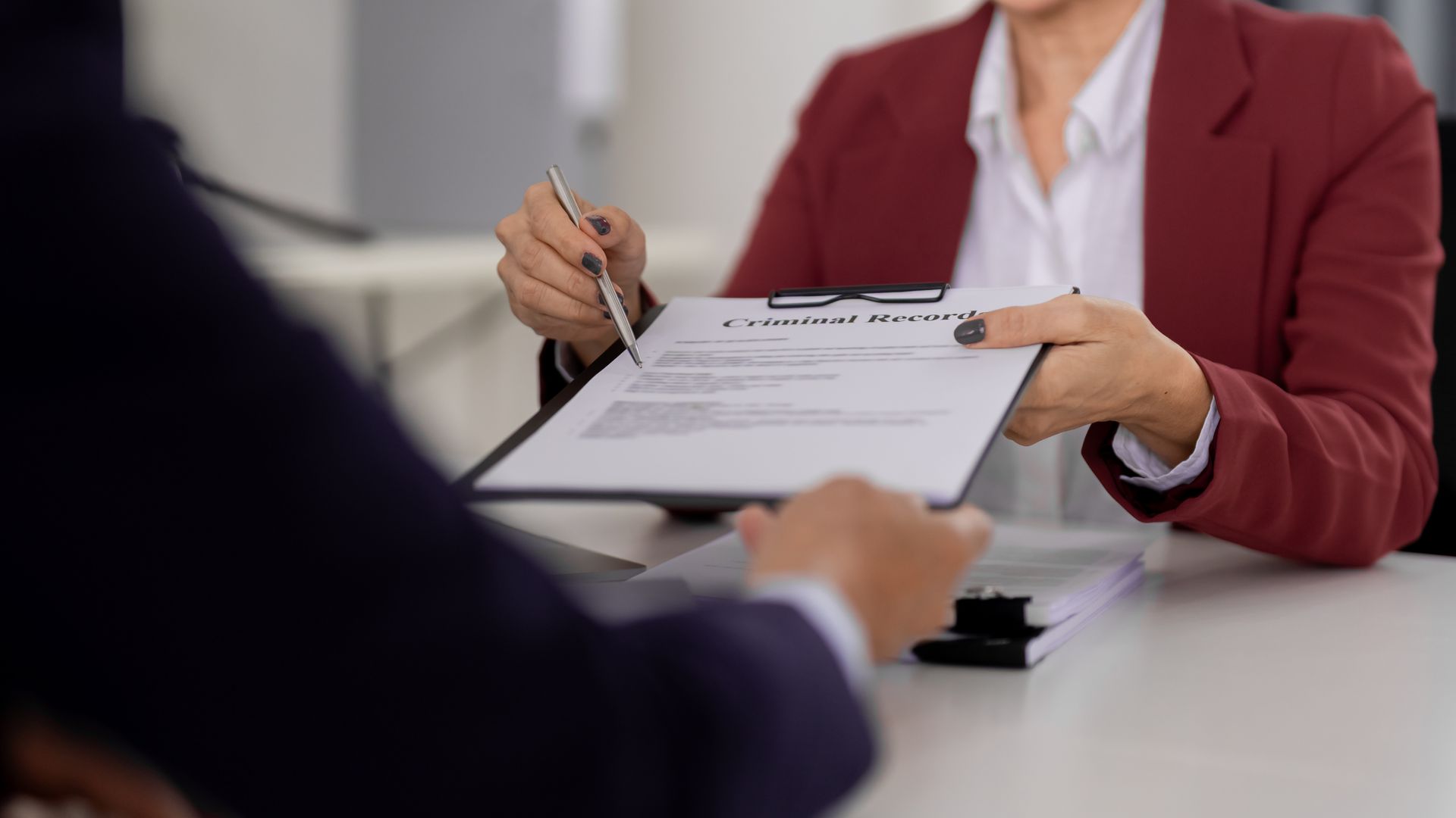 A lawyer reviewing a criminal record document during a legal consultation.