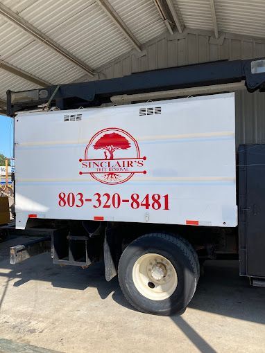 The logo and phone number for Sinclair's Tree Removal and Stump Grinding on the side of a truck in Lancaster SC