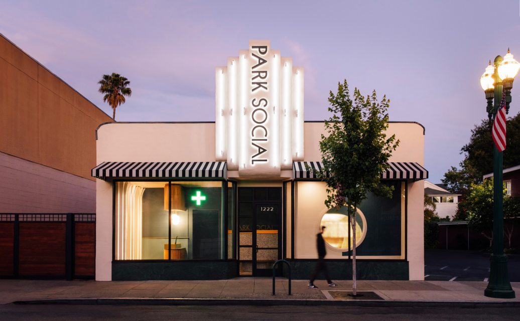 Purple and green cannabis bud with orange hairs on a white background.