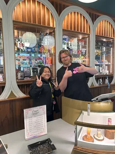 Purple and green cannabis bud with orange hairs on a white background.