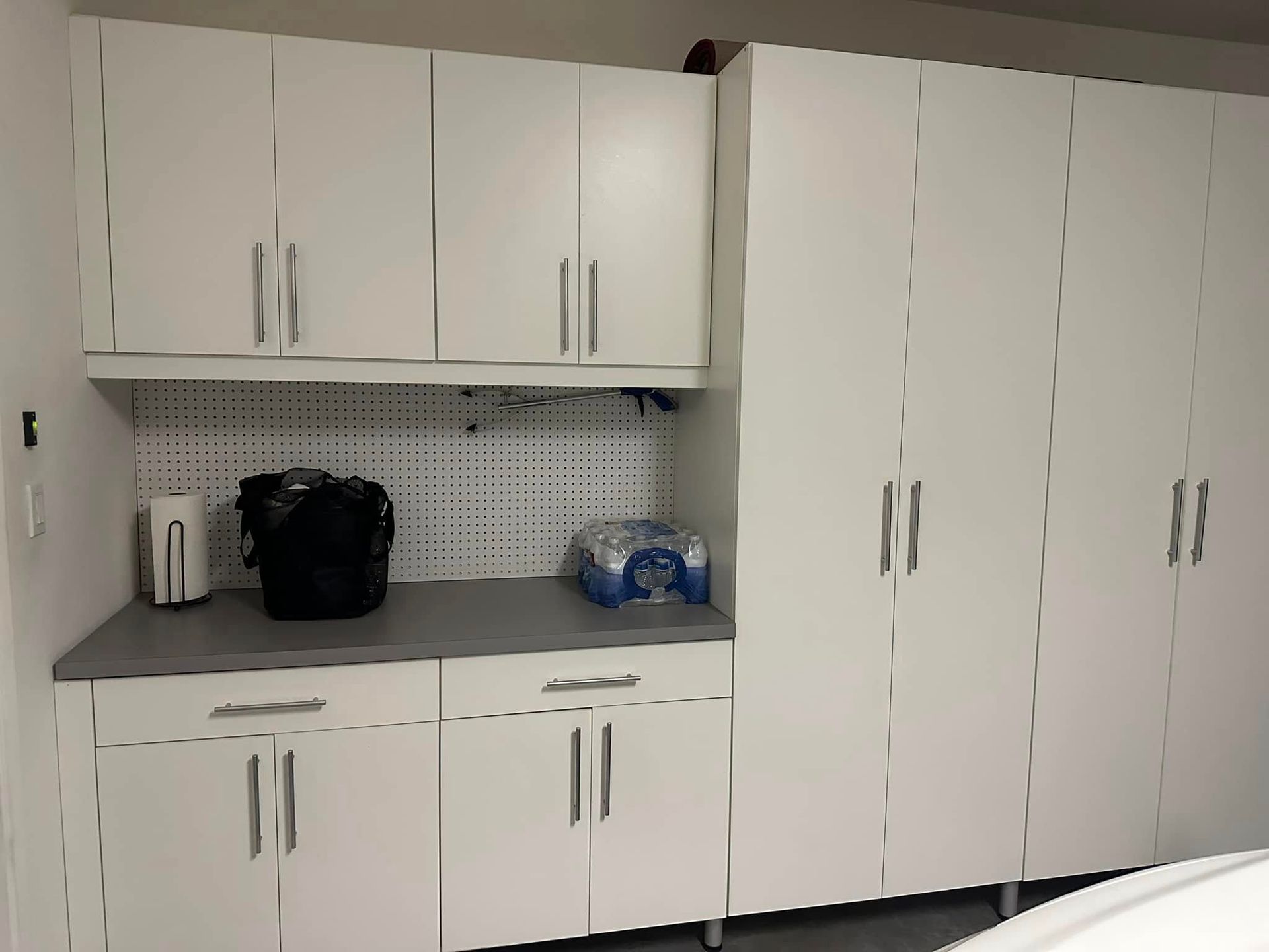 White storage cabinets with countertop, sink, and small appliances in a clean break room kitchenette.