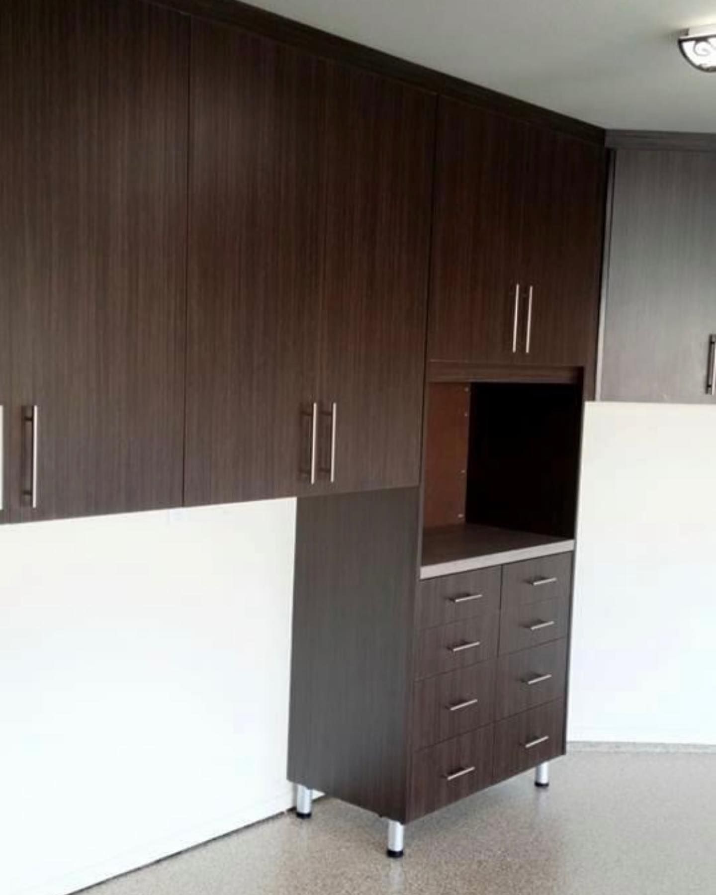 Built-in dark wood cabinets with drawers and open shelving in a room