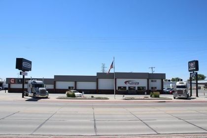 A brick building with white garage doors and a sign that says do not enter
