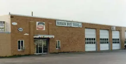 A brick building with white garage doors and a sign that says do not enter