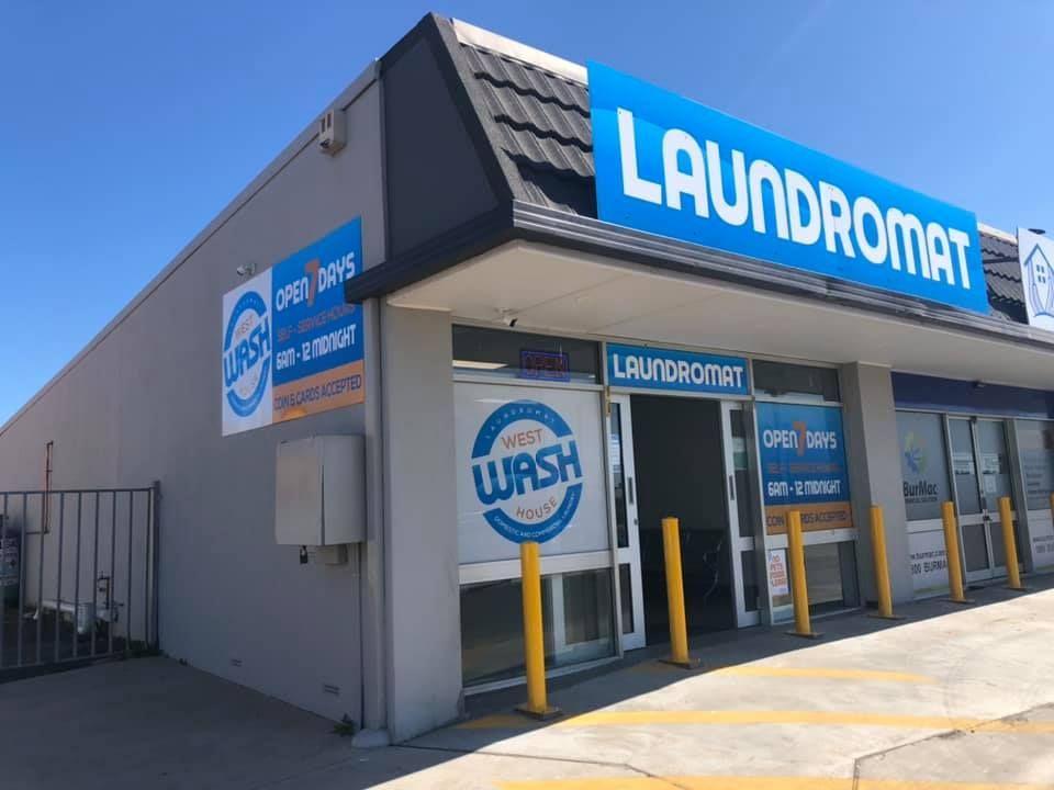 A laundromat with a blue sign on the side of the building — The Wash House& Laundrette in Dubbo, NSW