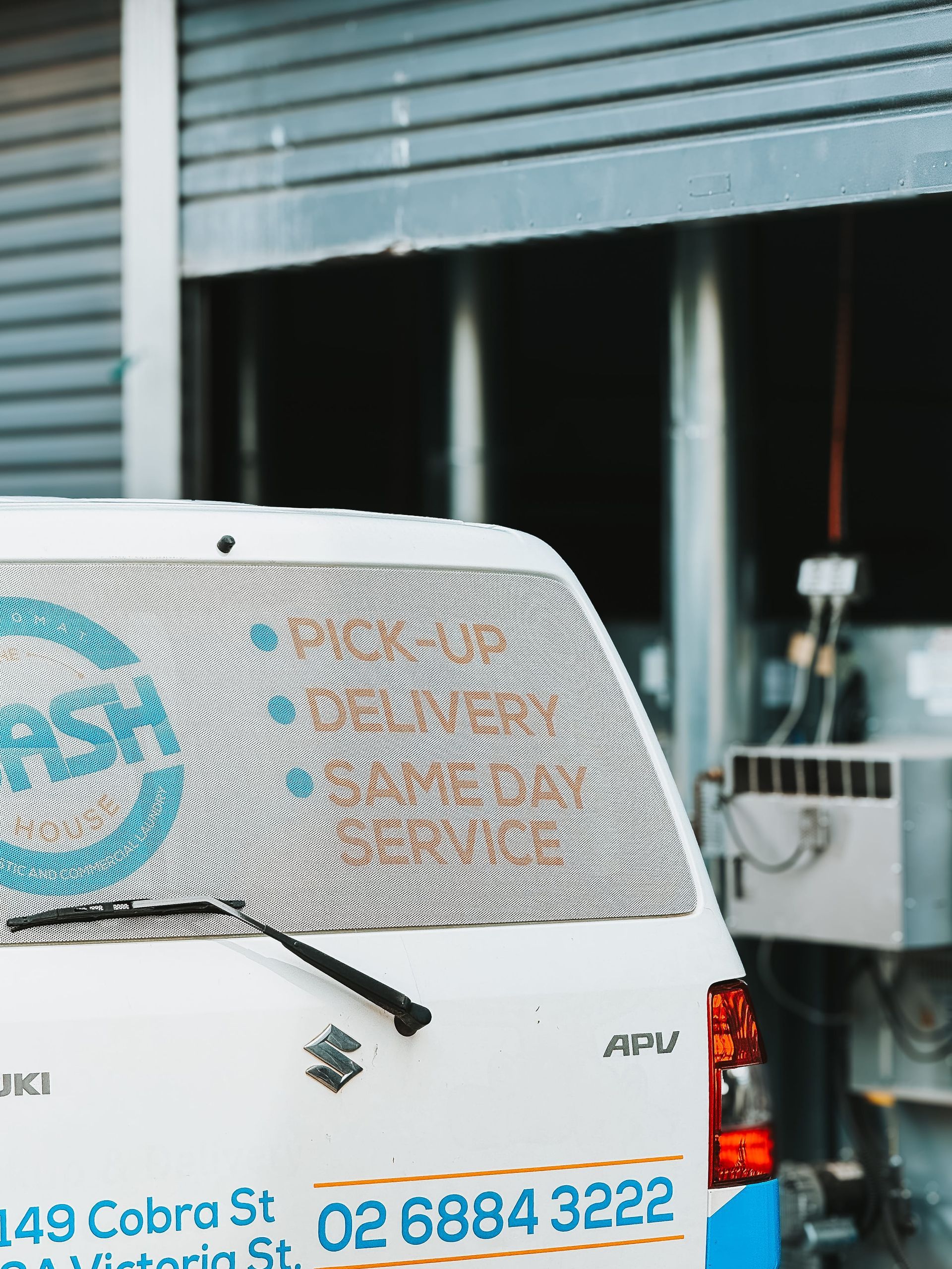 A White Suzuki Van is Parked in Front of a Building — The Wash House& Laundrette in Dubbo, NSW