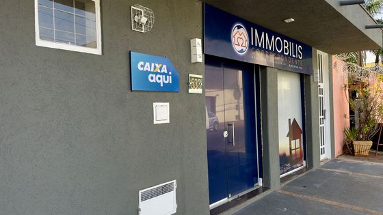 Um prédio com uma placa azul que diz caixa aqui