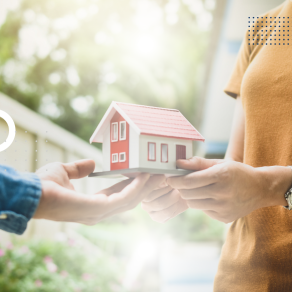 Uma pessoa está segurando uma casa modelo nas mãos