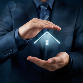 Um homem de terno e gravata está segurando uma casa em suas mãos