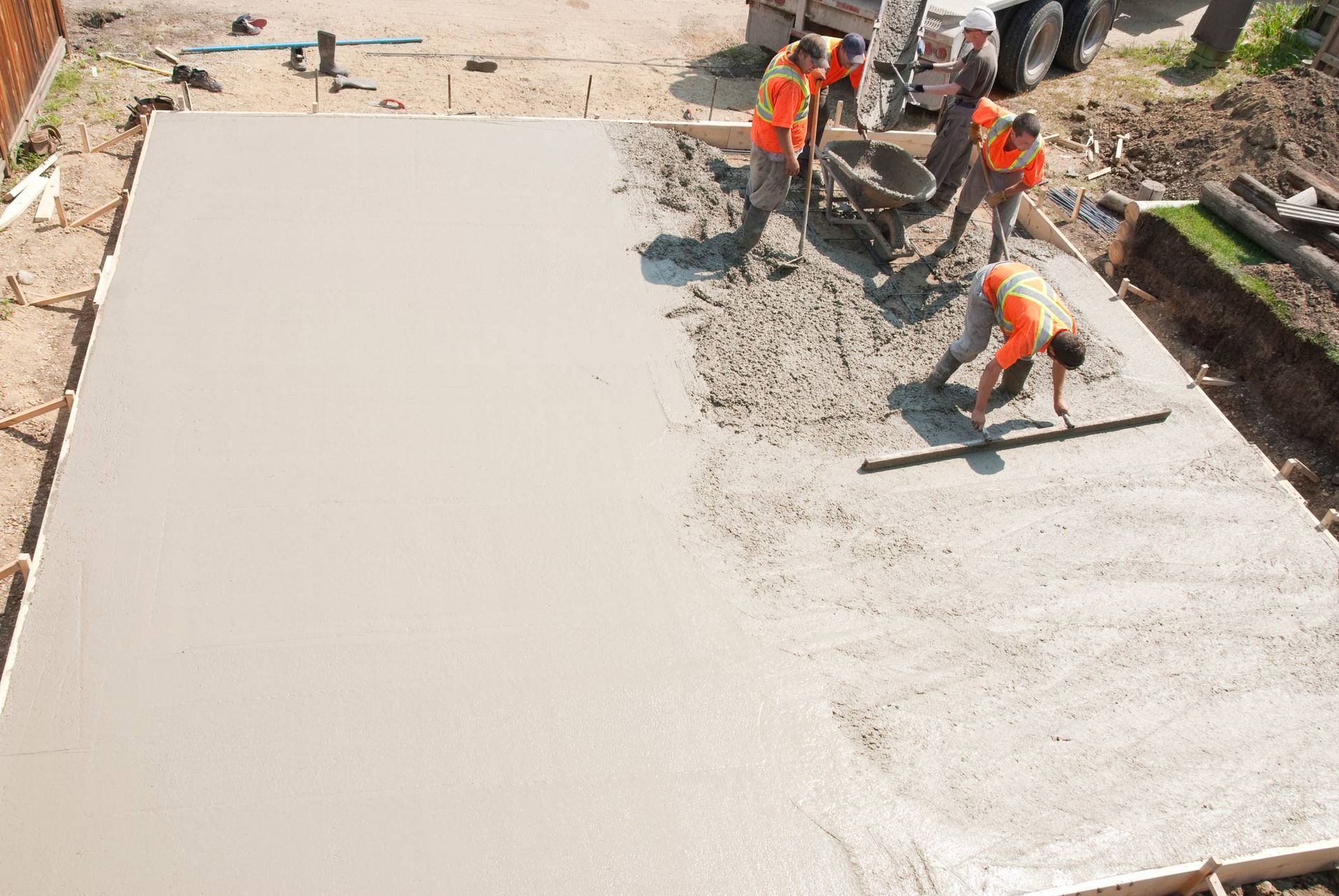 Workers pouring concrete for a large slab at a construction site
