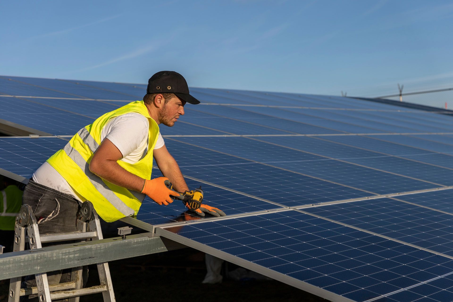 A man is working on a solar panel on top of a building