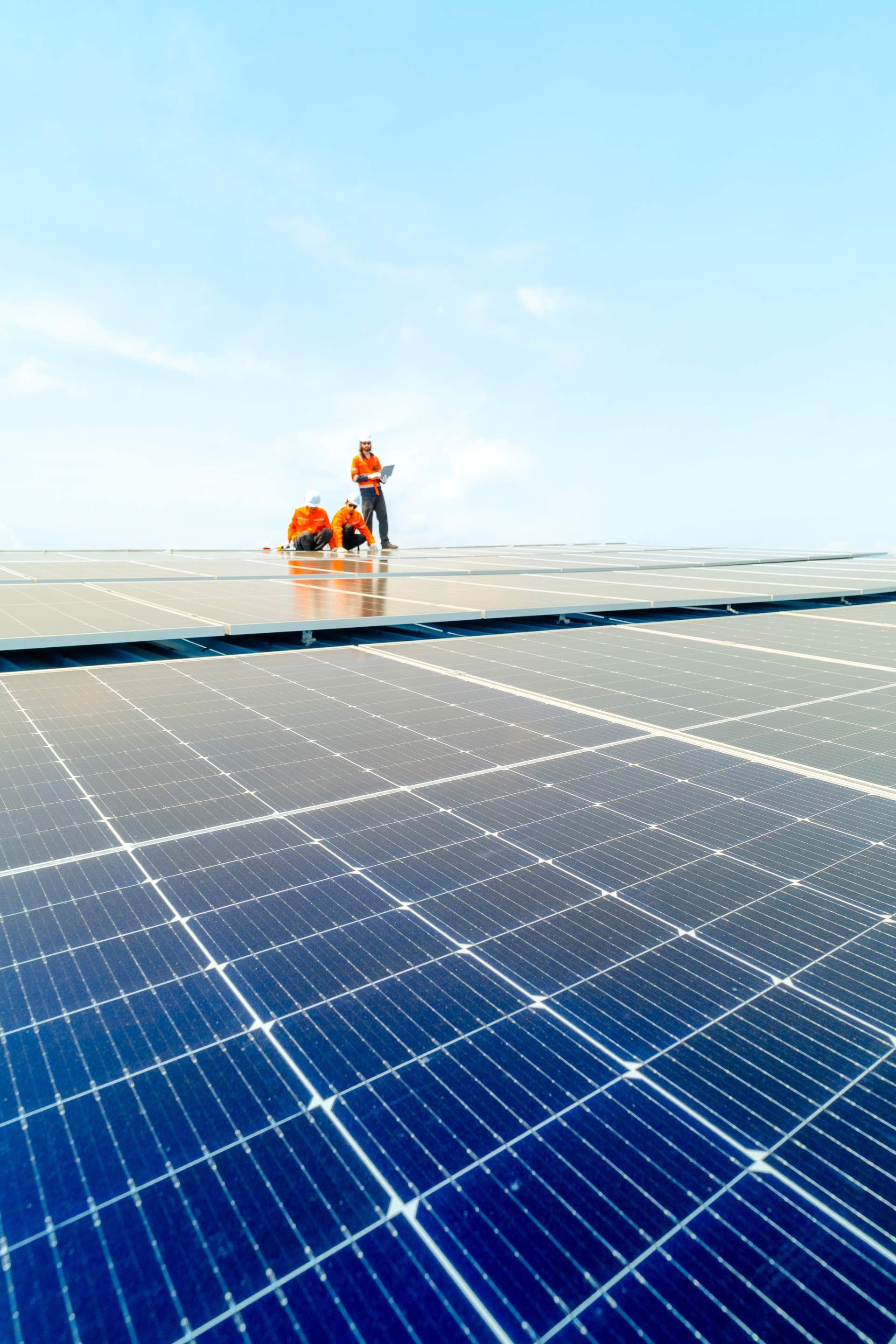 A group of people are working on a solar panel roof