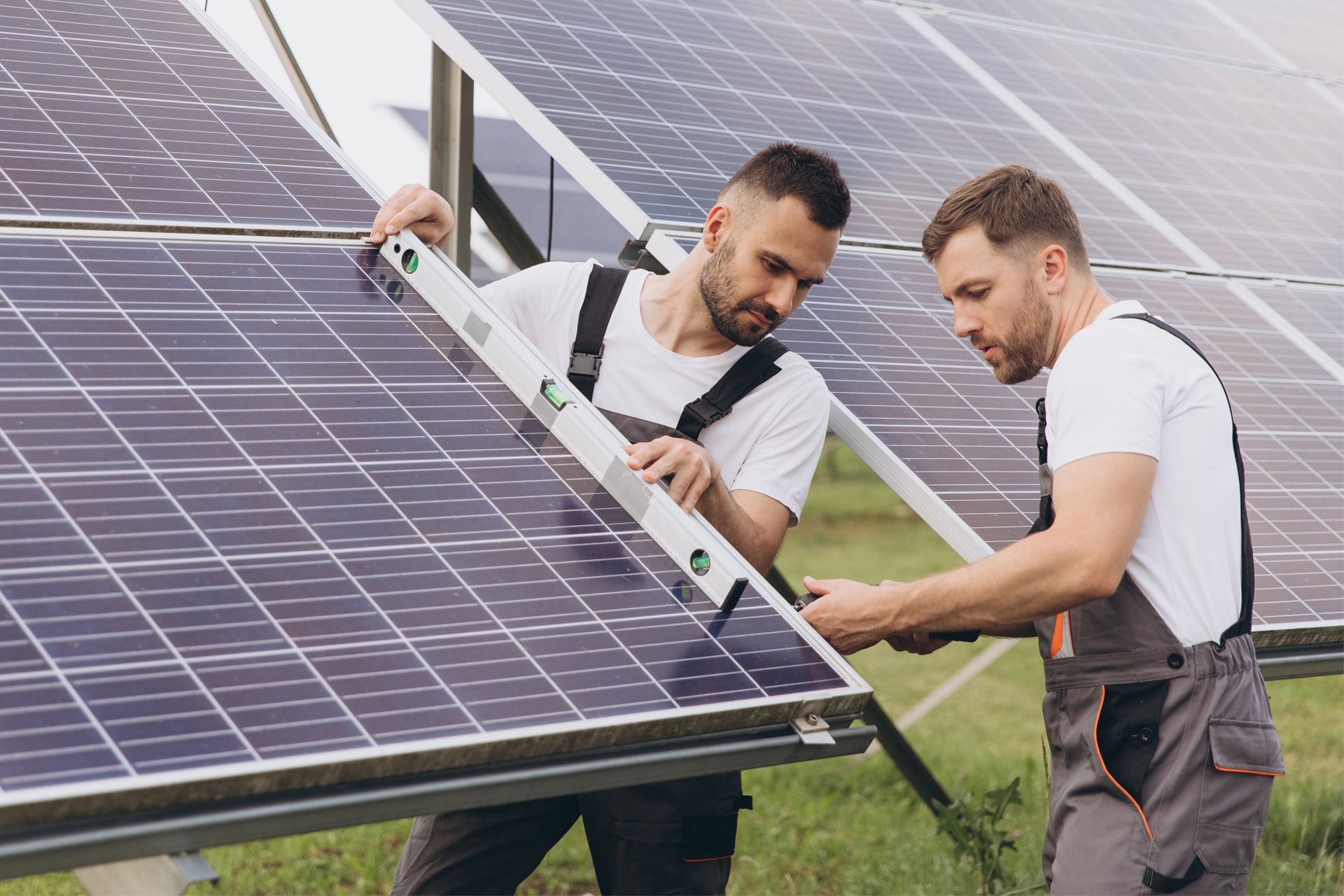 Two men are working on a solar panel with a level